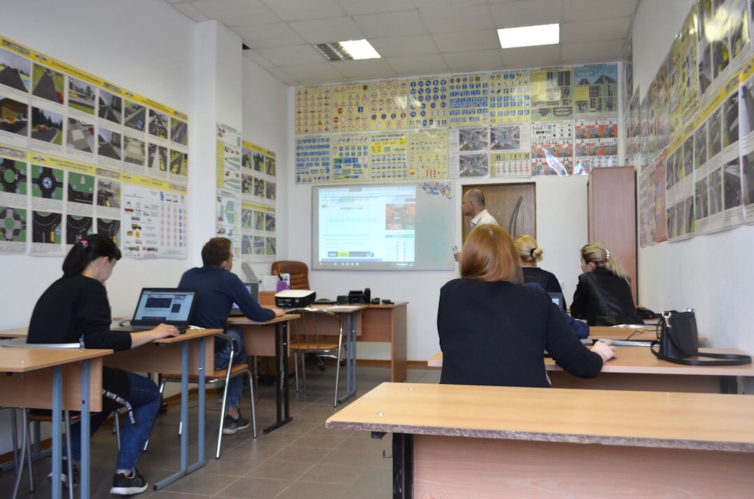 Students using tablets in a modern classroom with digital screens